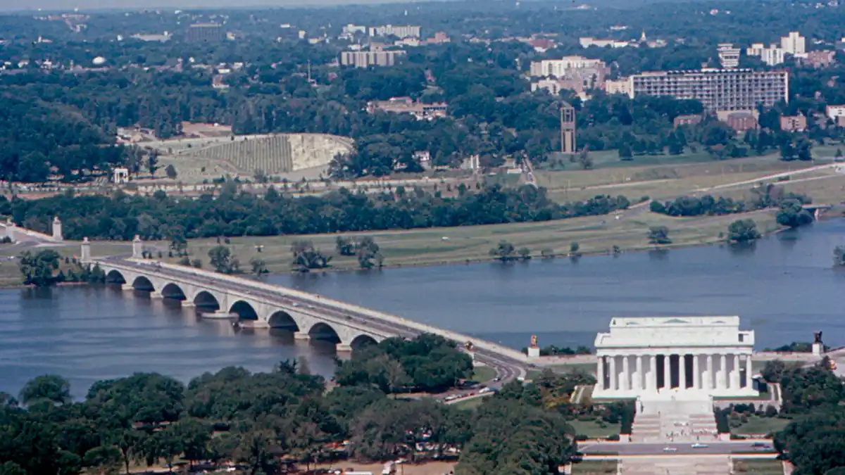 Historical documentary photograph showing the eastern span of the Arlington Memorial Bridge over the Potomac River connecting Washington D.C. to Virginia.