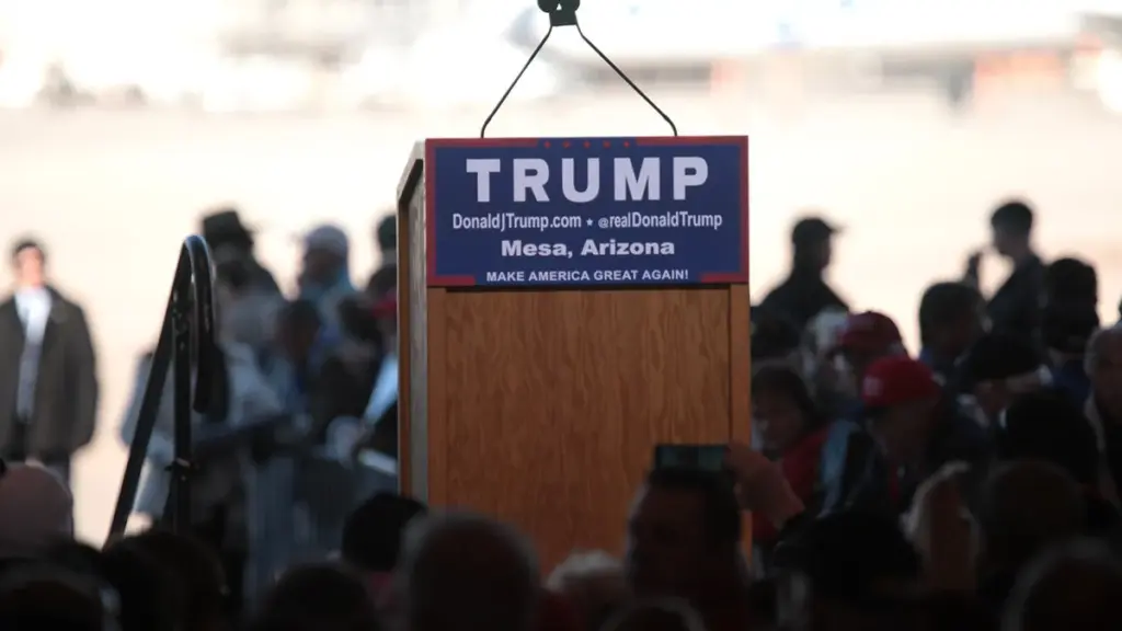 Donald Trump speaks from a podium at a campaign-style event.