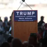 Donald Trump speaks from a podium at a campaign-style event.
