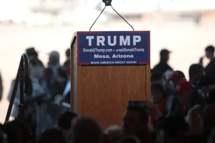 Donald Trump speaks from a podium at a campaign-style event.