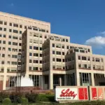 Exterior view of the Eli Lilly corporate center campus in Indianapolis, Indiana, with its entrance and landscaped grounds.