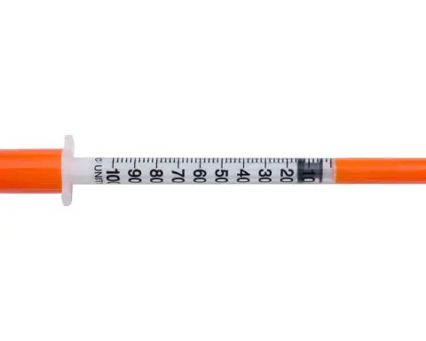 A medical syringe photographed against a plain background.