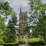 Brick clock and bell tower surrounded by trees and pathways on the Michigan State University campus in East Lansing.