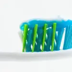 Close-up of an unbranded toothbrush with blue and white toothpaste applied to the bristles