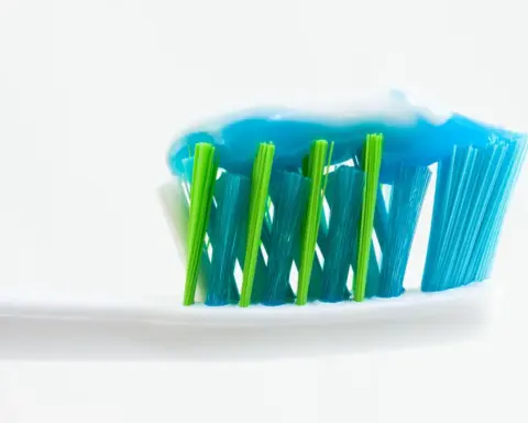 Close-up of an unbranded toothbrush with blue and white toothpaste applied to the bristles