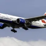 A British Airways Boeing 777-200ER widebody jetliner descending in clear skies.