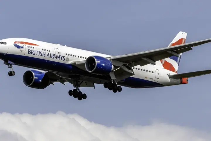 A British Airways Boeing 777-200ER widebody jetliner descending in clear skies.
