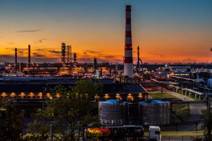 Industrial distillation columns, piping networks, and refining towers processing crude oil into refined diesel and fuel products.
