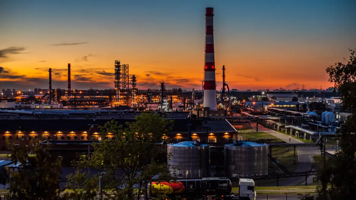 Industrial distillation columns, piping networks, and refining towers processing crude oil into refined diesel and fuel products.
