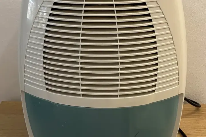 A household air dehumidifier unit with a European plug, illustrating the condensation technology atmospheric water generators rely on