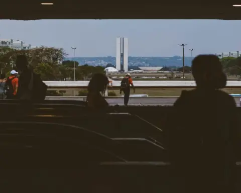 Silhouetted people look across the plaza toward the twin towers of Brazil National Congress in Brasilia.