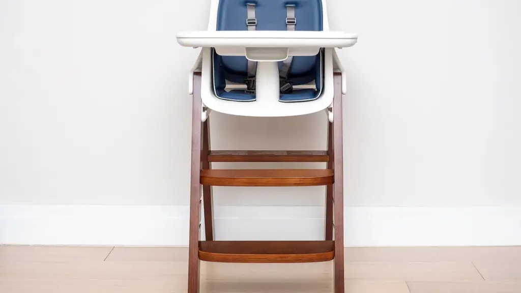 A wooden high chair with a feeding tray in a bright room.
