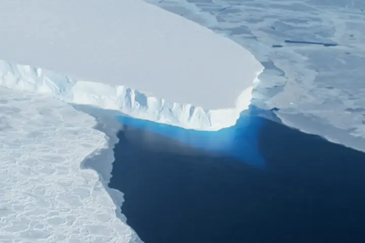 Blue ice calving front of Thwaites Glacier meeting the Southern Ocean, photographed from a NASA research aircraft