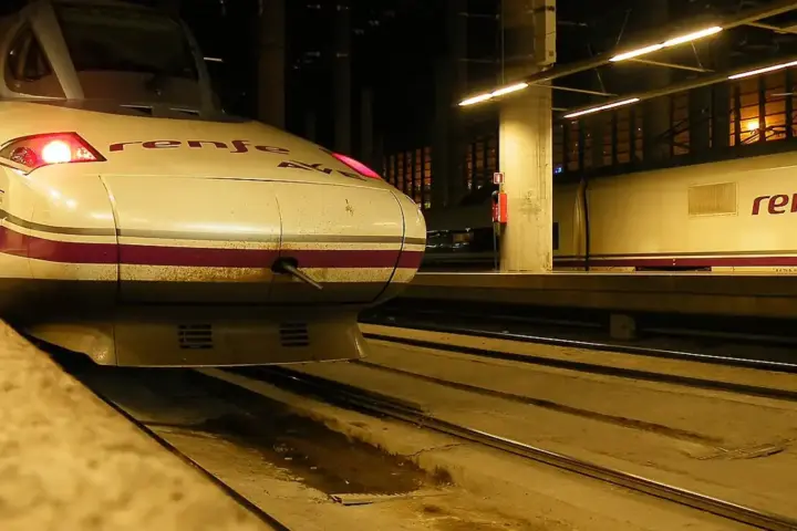 Renfe high-speed passenger train beside a boarding platform at Madrid Puerta de Atocha railway station in Spain.