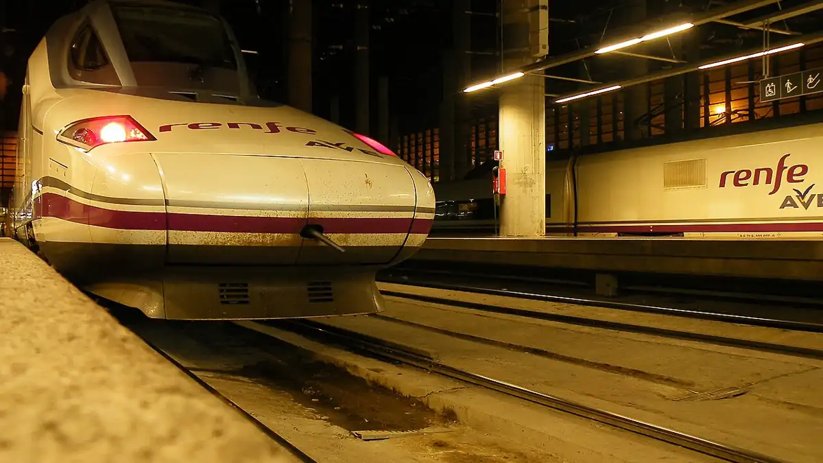 Renfe high-speed passenger train beside a boarding platform at Madrid Puerta de Atocha railway station in Spain.