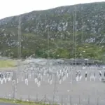 Pumped-storage hydroelectric power station switchyard set against a mountainous reservoir landscape