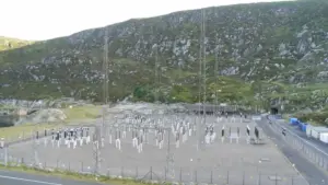 Pumped-storage hydroelectric power station switchyard set against a mountainous reservoir landscape