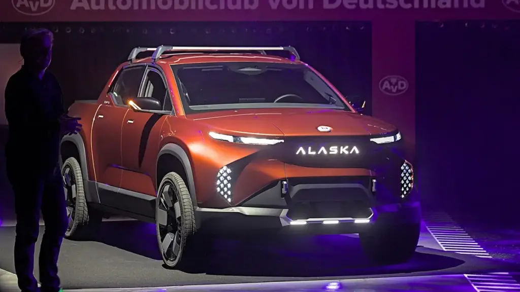 An electric pickup truck on display at an indoor motor show.