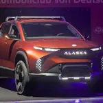 An electric pickup truck on display at an indoor motor show.