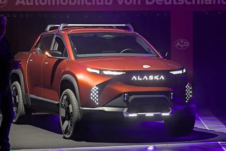 An electric pickup truck on display at an indoor motor show.