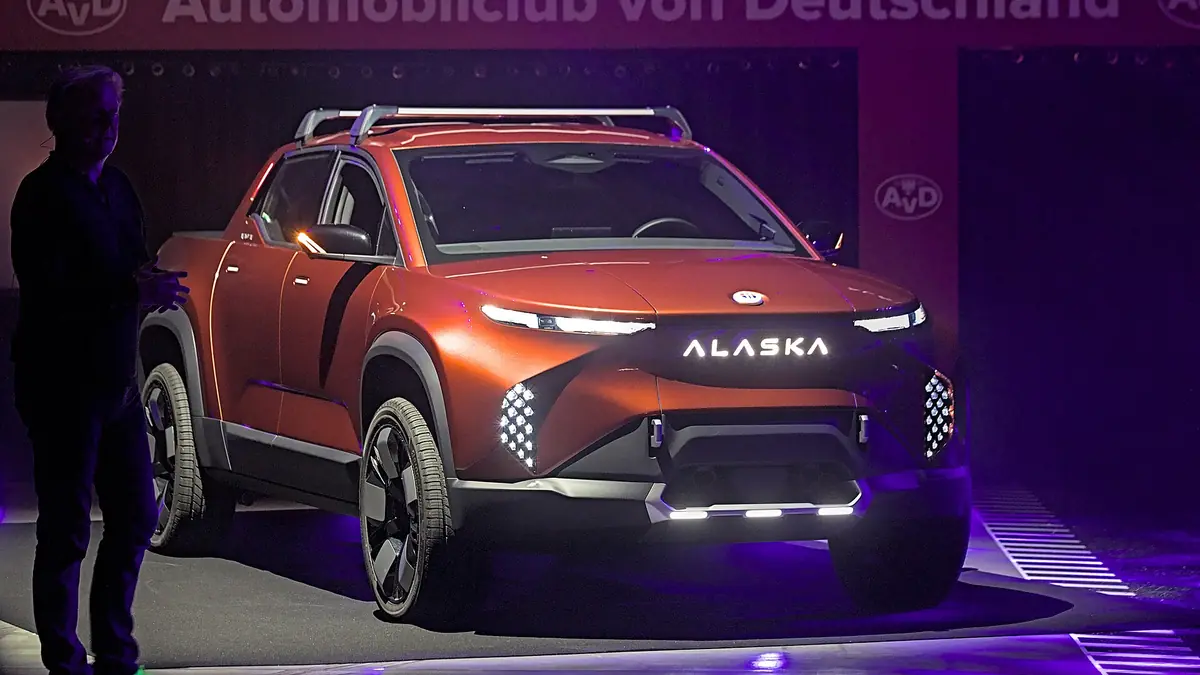 An electric pickup truck on display at an indoor motor show.