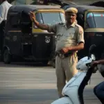 Traffic officer managing vehicles at a busy Indian road intersection.