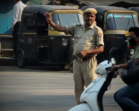 Traffic officer managing vehicles at a busy Indian road intersection.