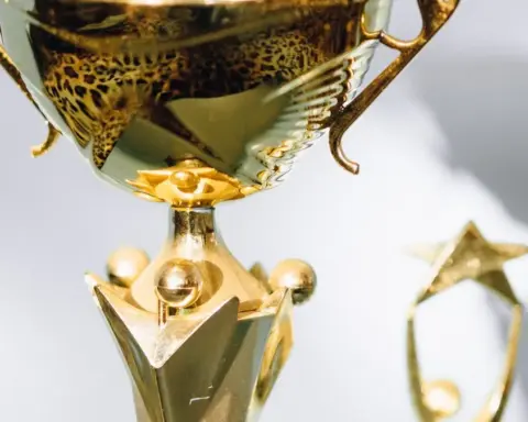Close view of a polished gold trophy with a smaller trophy blurred in the background.