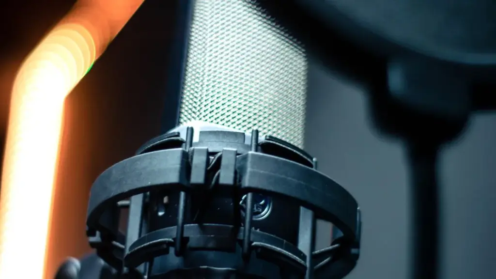 Close-up of a professional studio microphone and pop filter used for voice recording.
