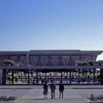 Front view of the stone Knesset parliament building and surrounding plaza in Jerusalem.