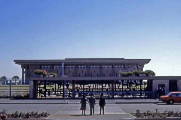 Front view of the stone Knesset parliament building and surrounding plaza in Jerusalem.
