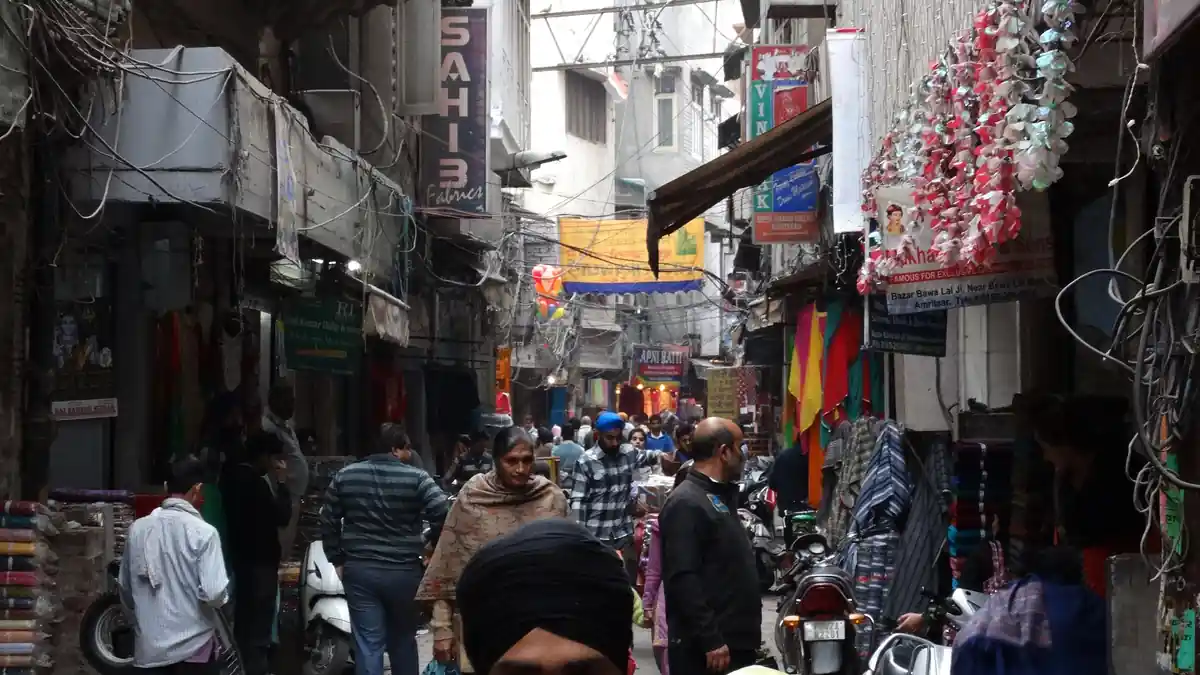 Commercial street scene with vehicles and storefronts in Amritsar Punjab