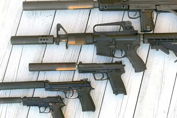 Cylindrical metallic firearm sound suppressors showing machined threads and modular baffle design.