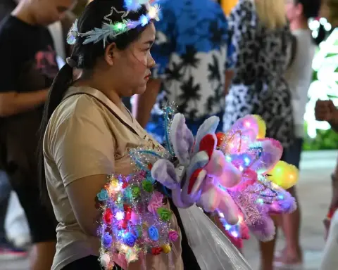 Brightly lit colourful light-up toys and accessories on display at a bustling night market stall.