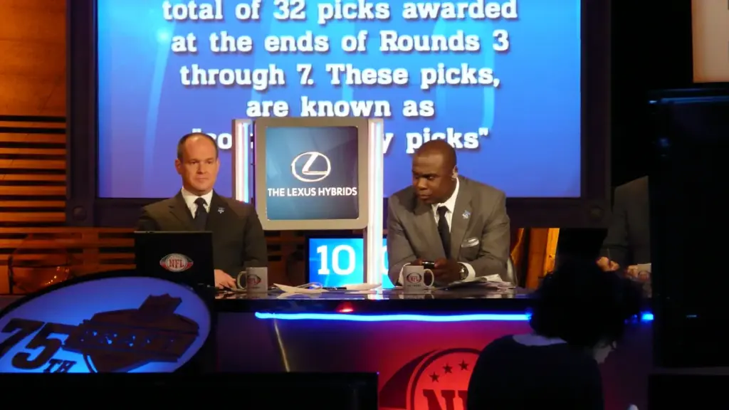 Hall of Fame running back Marshall Faulk seated at a broadcast desk.