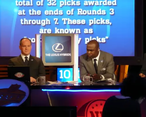 Hall of Fame running back Marshall Faulk seated at a broadcast desk.