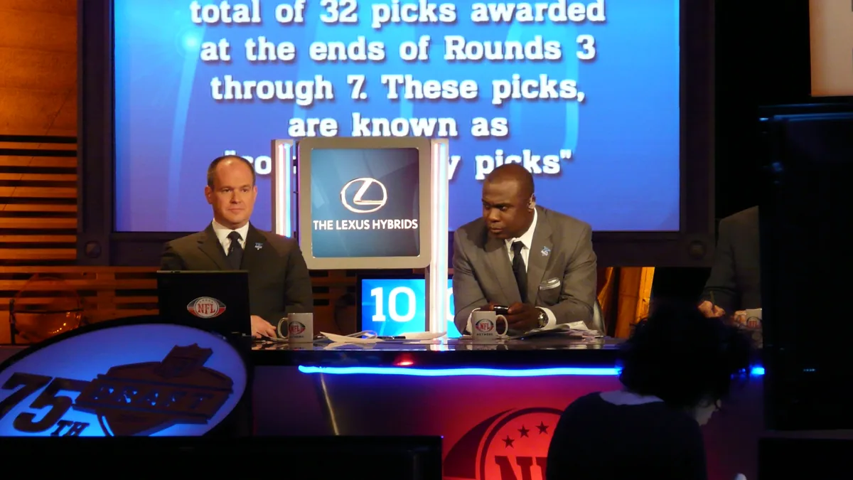 Hall of Fame running back Marshall Faulk seated at a broadcast desk.