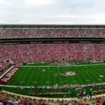 Panoramic view of the full grandstands, field, and upper decks of Bryant-Denny Stadium during a collegiate athletic event in Alabama.