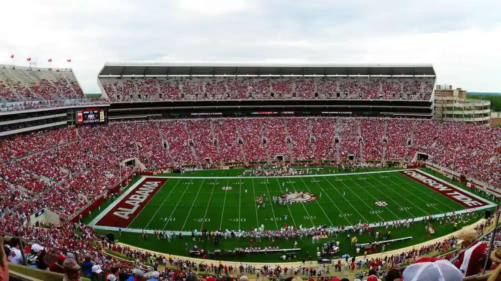 Panoramic view of the full grandstands, field, and upper decks of Bryant-Denny Stadium during a collegiate athletic event in Alabama.