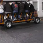 Open-air pedal tavern carrying multiple passengers along a city street, similar to the vehicle involved in the Nashville crash