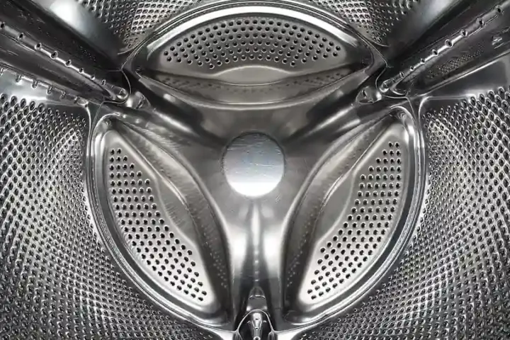 Inside a front-loading washing machine drum, illustrating laundry microfibre shedding
