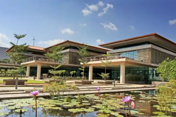 A modern glass corporate headquarters building against a blue sky.