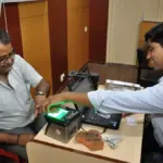 Person placing fingers on a biometric scanner during identity enrollment