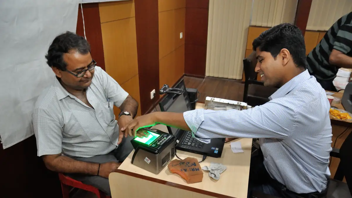 Person placing fingers on a biometric scanner during identity enrollment