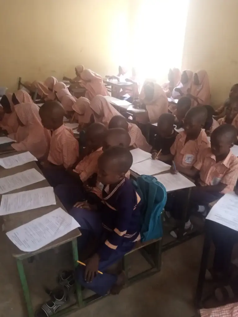 Students writing examinations in a classroom setting.