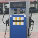 Close-up photograph of a commercial automotive fuel dispenser with pump nozzles mounted at a service station in Texas.