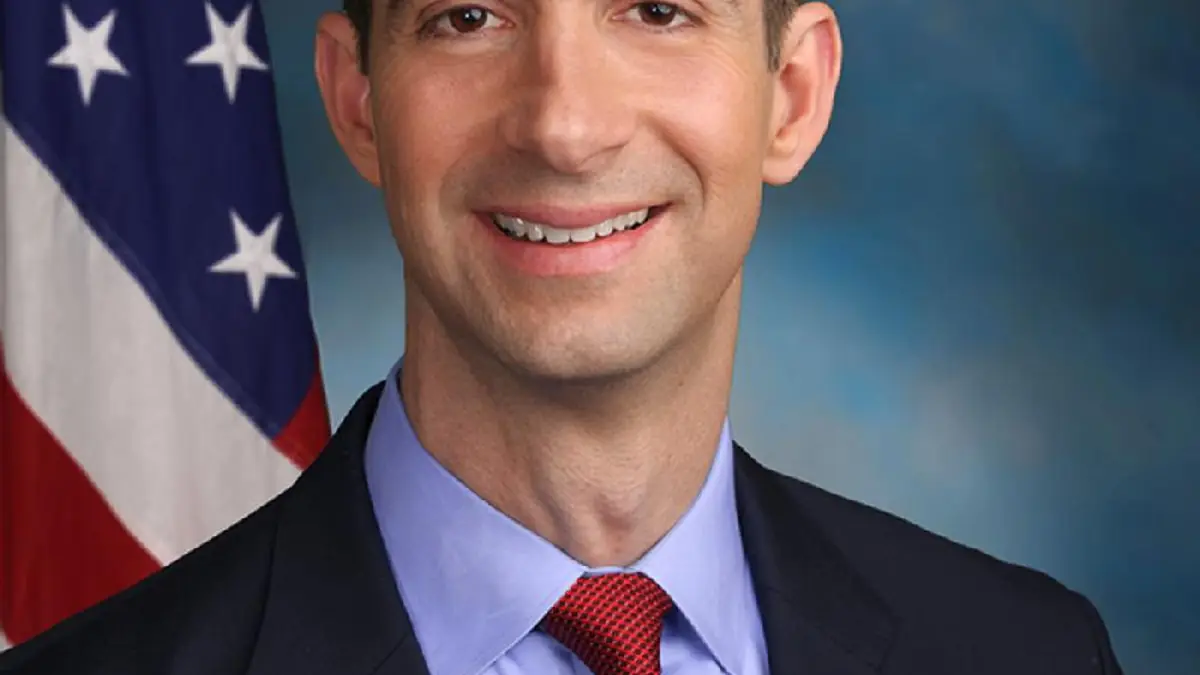 Official studio portrait of U.S. Senator Tom Cotton in a dark suit with tie and American flag lapel pin
