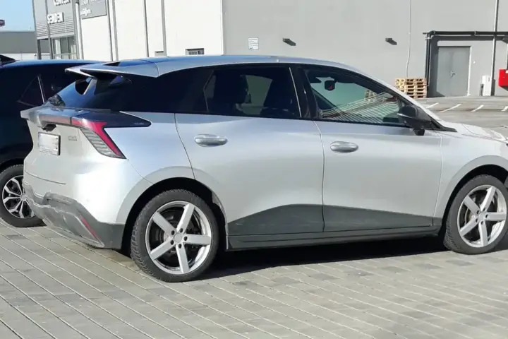 An electric vehicle on display at an automotive exhibition with modern design and branding visible