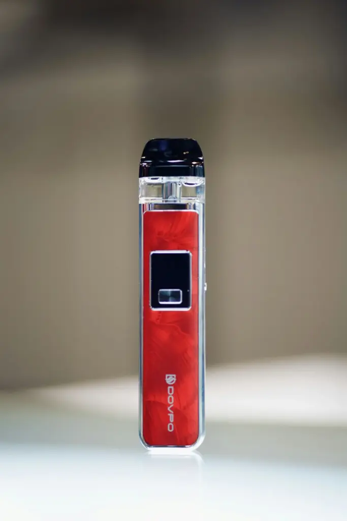 A red and silver vape device on a plain white surface