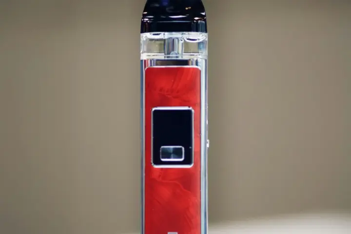 A red and silver vape device on a plain white surface